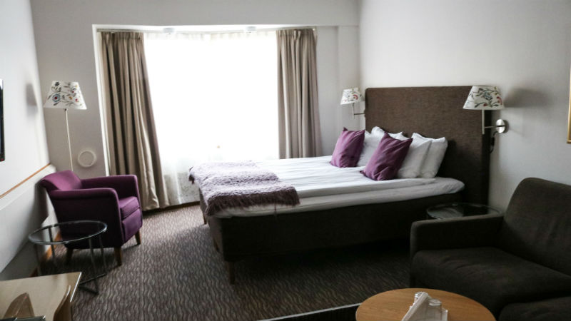 Dubbelsng med ftljer och bord i ett rum p Mora Hotell