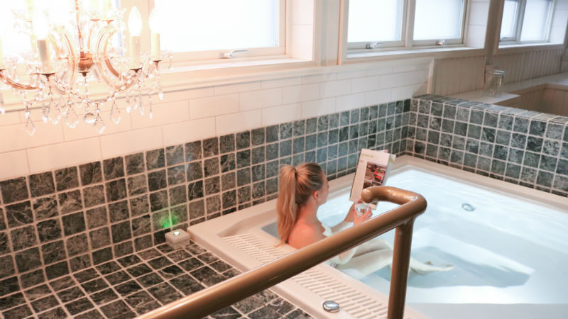 Kvinna lser tidningen i spapoolen p Mora Hotell